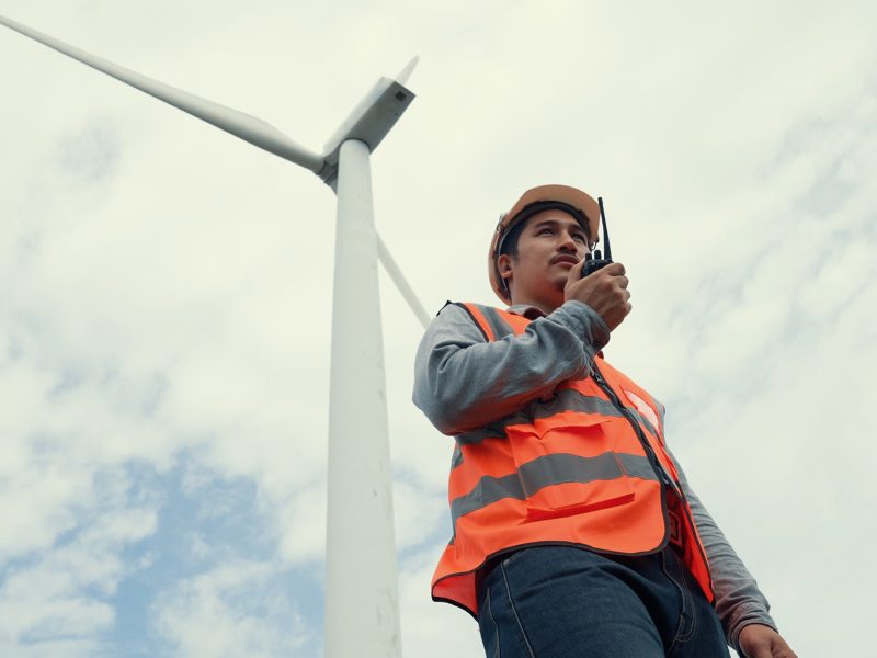 Engineer working on a wind turbine with the sky background. Progressive ideal for the future production of renewable, sustainable energy. Energy generation from wind turbine.